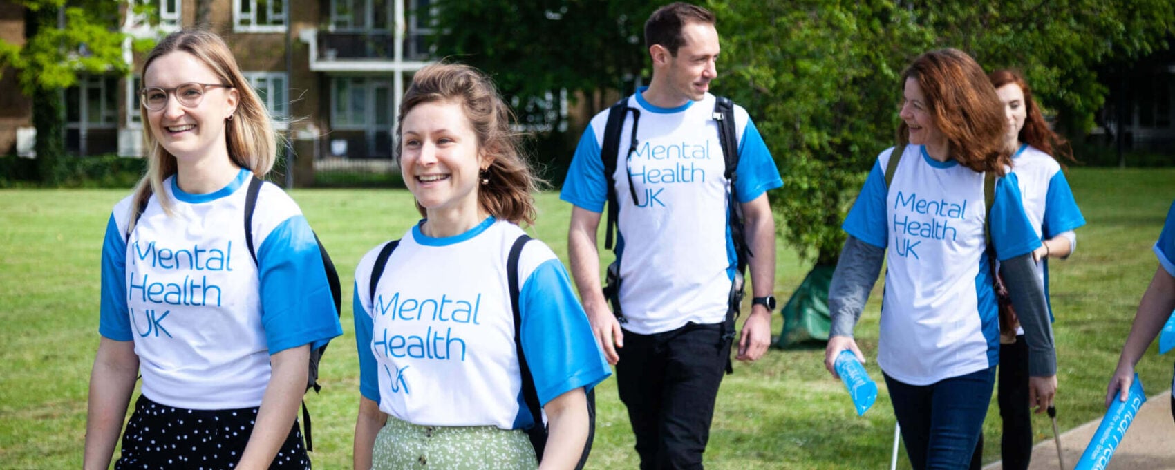 People walking in a park wearing Mental Health UK t-shirts