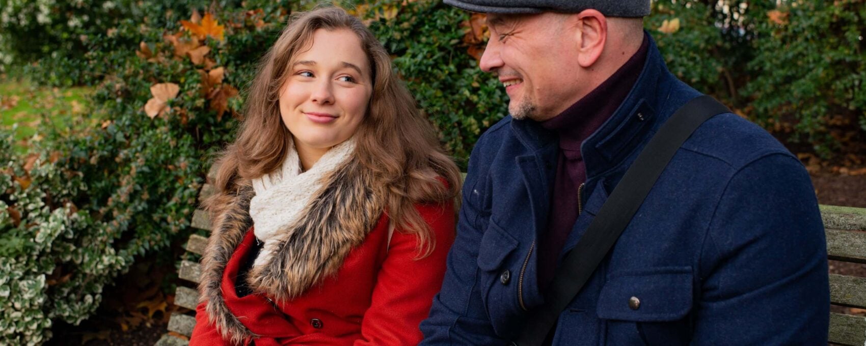 Father and daughter talking while sat on park bench