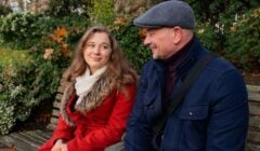 Father and daughter talking while sat on park bench