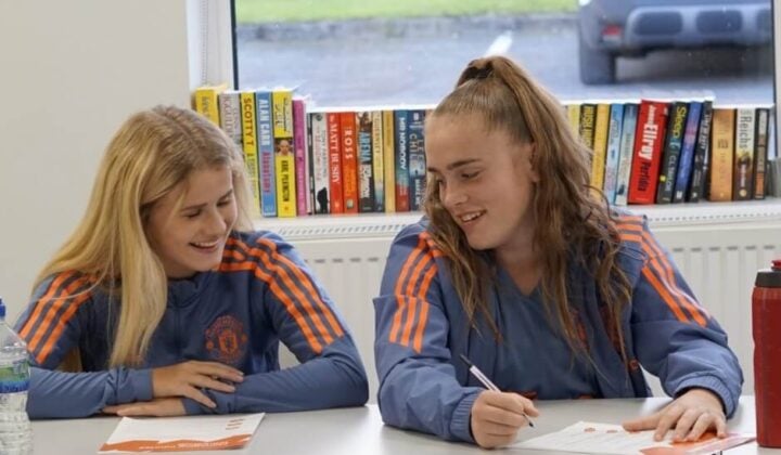 Two young Manchester United players in a mental health workshop discussing the materials