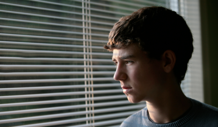 Teenage boy looking out the window