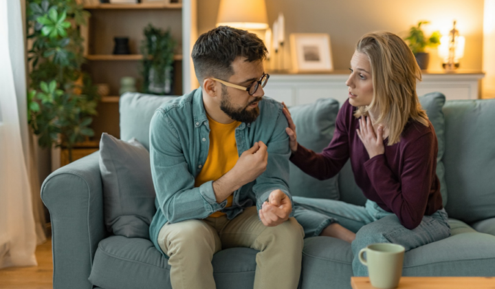 Wife talking to her husband on the sofa